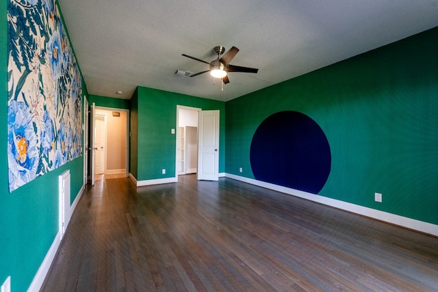 unfurnished room featuring baseboards, visible vents, dark wood-style floors, ceiling fan, and a textured ceiling