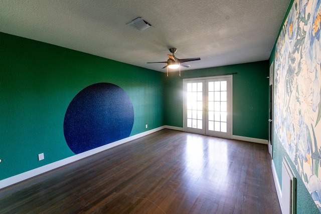 empty room featuring french doors, visible vents, a textured ceiling, wood finished floors, and baseboards