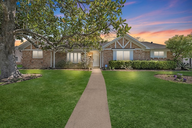 view of front of home featuring brick siding and a front yard