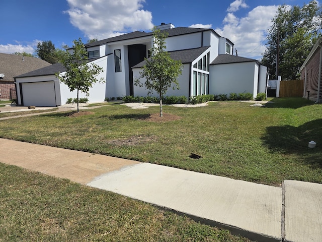 view of front of home featuring a front yard and a garage