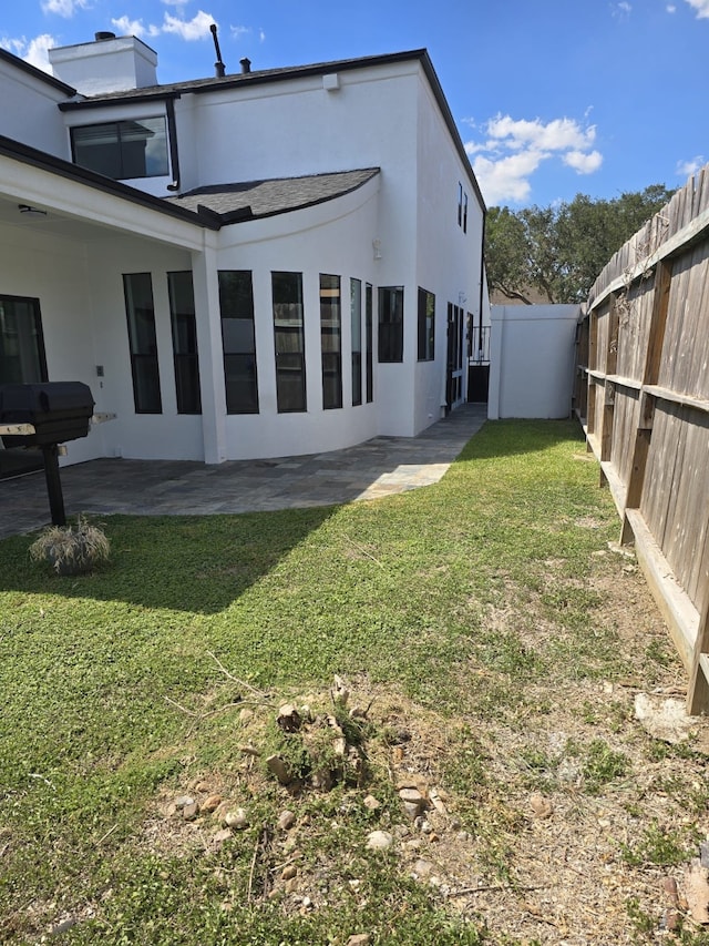 rear view of property with a patio and a yard