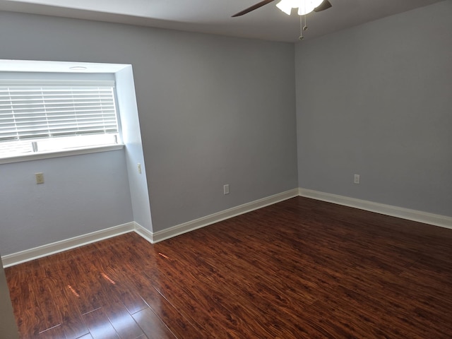 empty room with ceiling fan and dark wood-type flooring