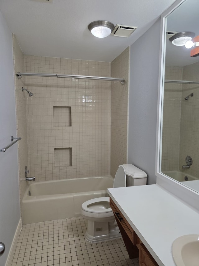 full bathroom featuring tiled shower / bath combo, vanity, toilet, and tile patterned floors