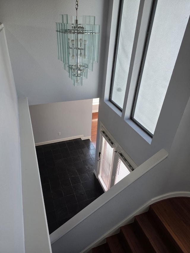 stairway with a chandelier and hardwood / wood-style flooring