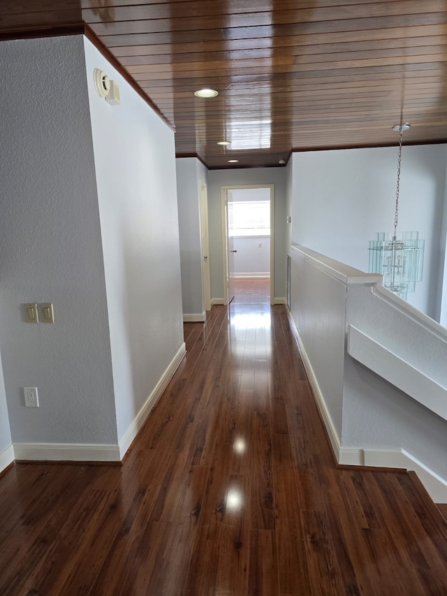 hall featuring an inviting chandelier, wood ceiling, dark hardwood / wood-style floors, and ornamental molding