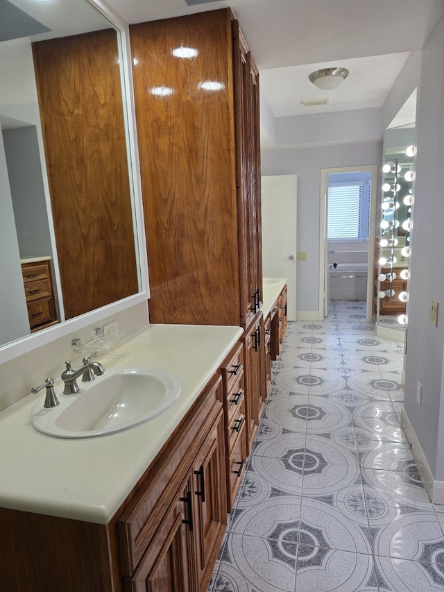 bathroom with tile patterned flooring, vanity, and a washtub