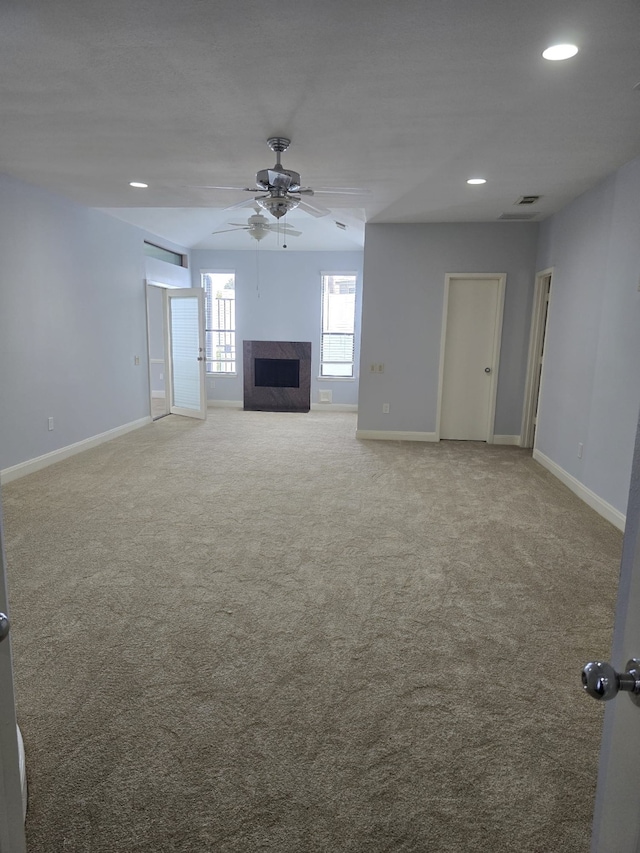 unfurnished living room with carpet, a fireplace, and ceiling fan