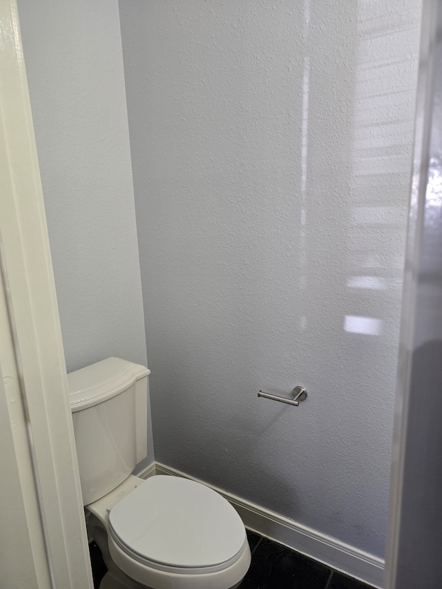 bathroom with toilet and tile patterned floors