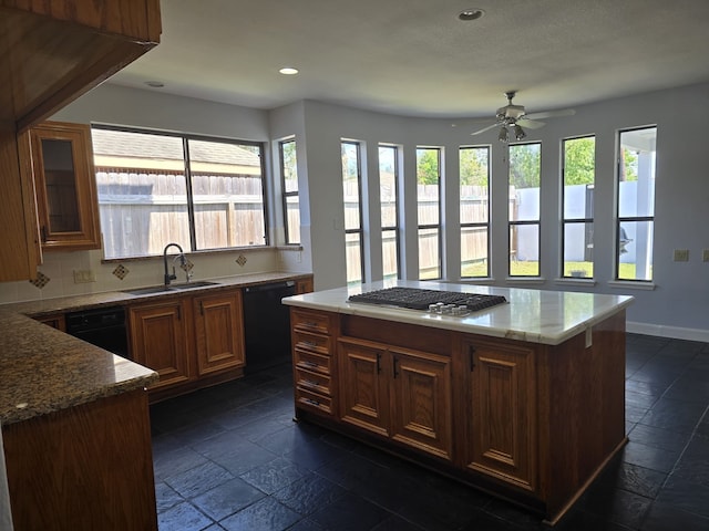 kitchen featuring backsplash, black dishwasher, a kitchen island, stainless steel gas cooktop, and sink