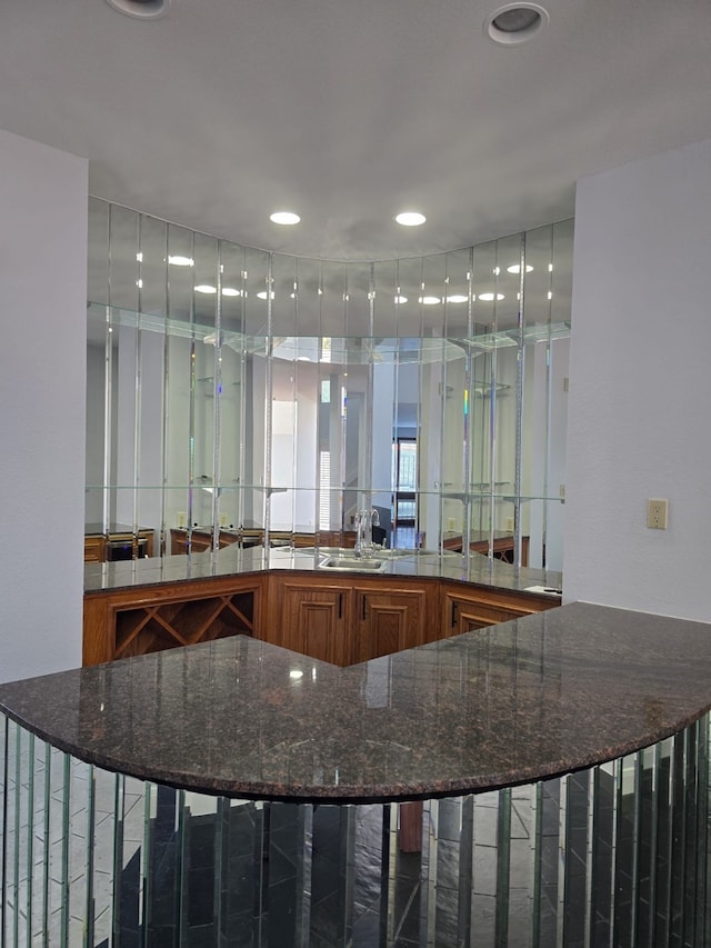 bar featuring dark stone countertops and sink