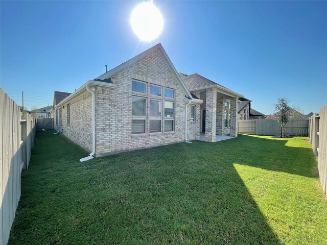 back of house featuring a lawn