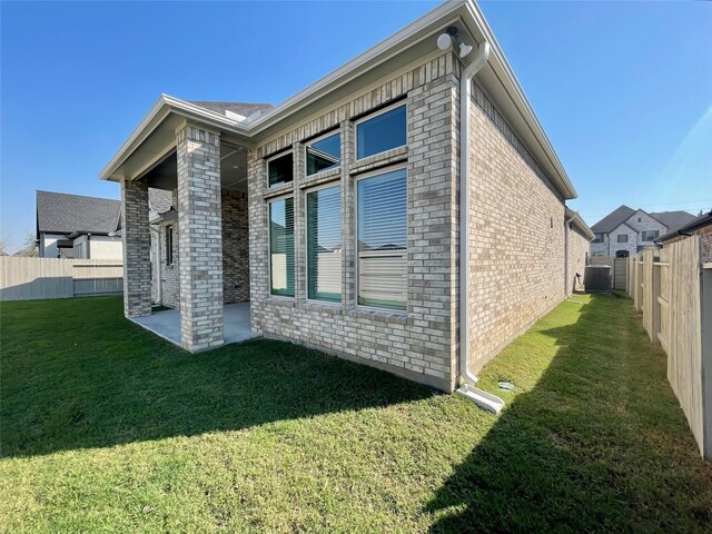 view of property exterior featuring a yard and central AC