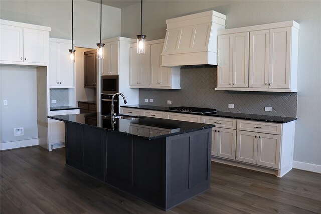 kitchen with white cabinets, custom exhaust hood, sink, a kitchen island with sink, and stainless steel gas stovetop