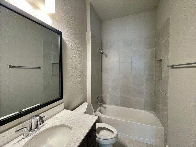 full bathroom with vanity, tiled shower / bath combo, and toilet