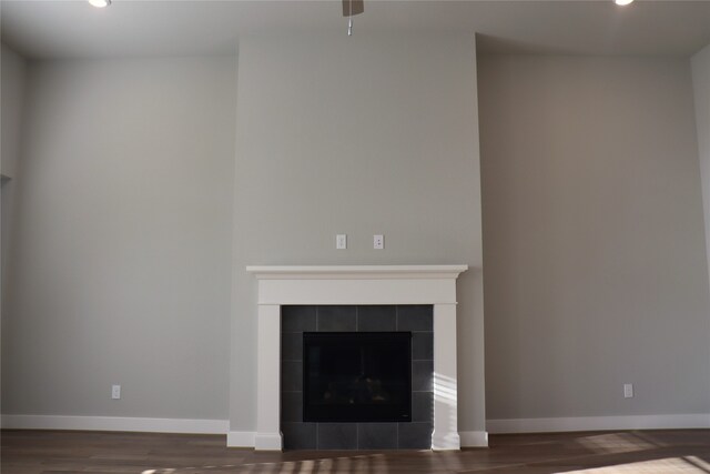 unfurnished living room featuring a fireplace and dark wood-type flooring