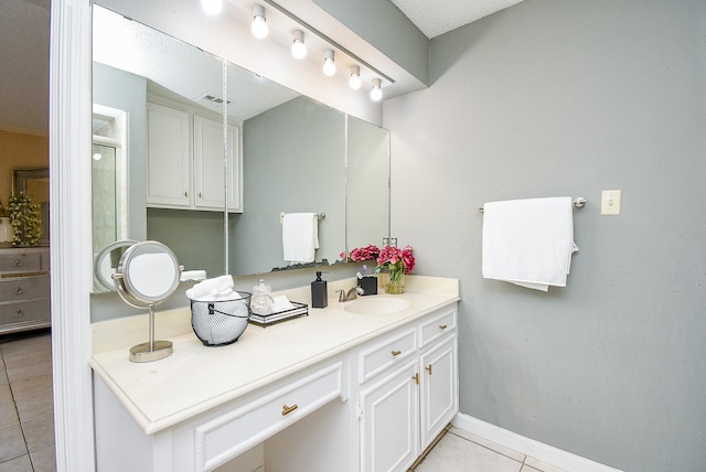 bathroom with a textured ceiling, tile patterned flooring, and vanity