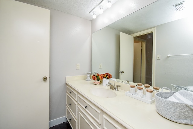 bathroom with a textured ceiling and vanity