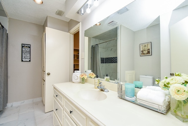 bathroom with a textured ceiling, vanity, toilet, and a shower with shower curtain