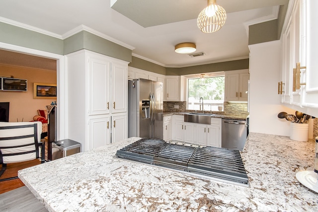 kitchen featuring sink, white cabinetry, light hardwood / wood-style flooring, stainless steel appliances, and decorative backsplash