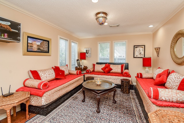 living room featuring ornamental molding, a textured ceiling, and hardwood / wood-style floors