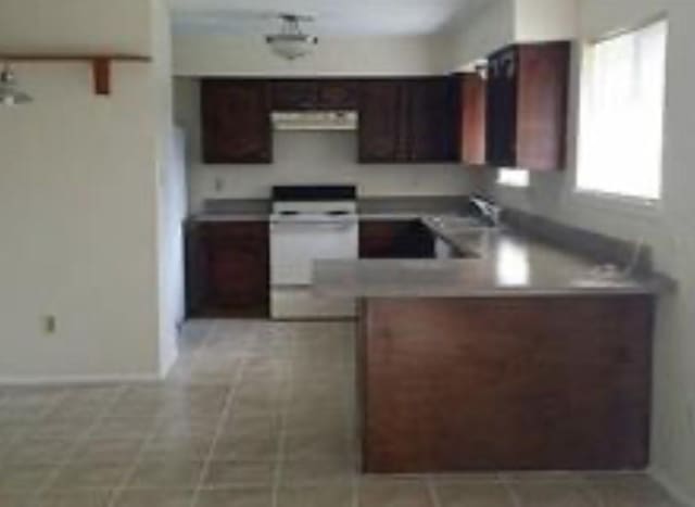 6222 Brookgate Dr, Spring, TX 77373 - kitchen with range hood, white electric range, a sink, light countertops, and a peninsula