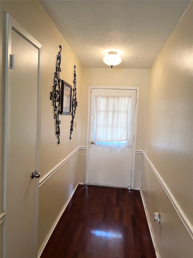 doorway to outside featuring a textured ceiling and dark hardwood / wood-style floors