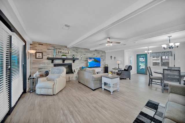 living room featuring ceiling fan with notable chandelier, light wood-type flooring, and beam ceiling