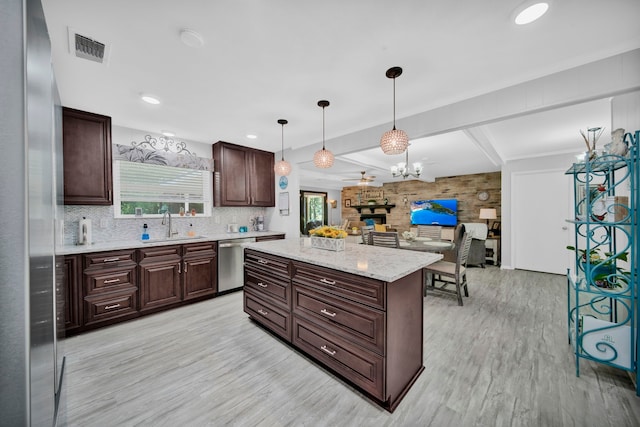 kitchen with pendant lighting, sink, dishwasher, a center island, and light hardwood / wood-style floors