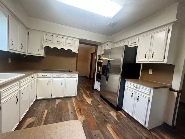 kitchen featuring dark hardwood / wood-style floors, white cabinetry, and stainless steel appliances