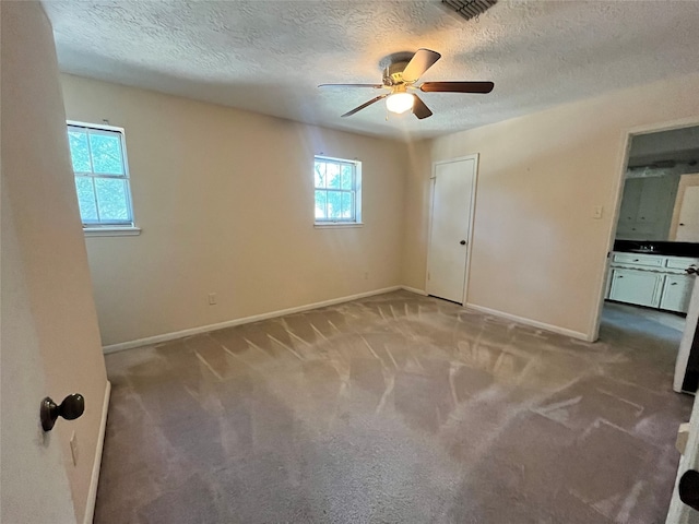 spare room with ceiling fan, light colored carpet, and a healthy amount of sunlight