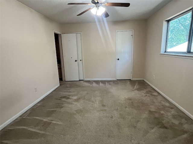 carpeted spare room featuring ceiling fan