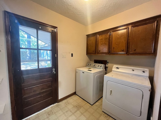 laundry area with cabinets, separate washer and dryer, and a textured ceiling