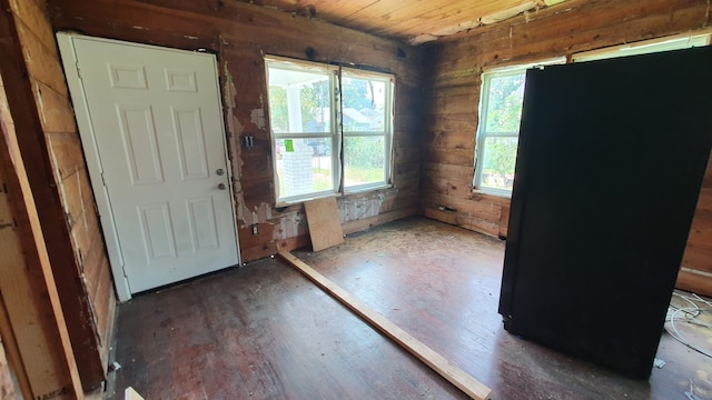 foyer entrance with wood ceiling, wood walls, and dark wood-type flooring