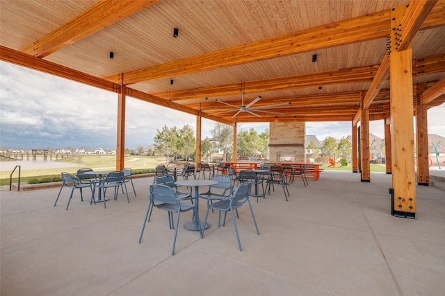 view of patio featuring ceiling fan and a large fireplace