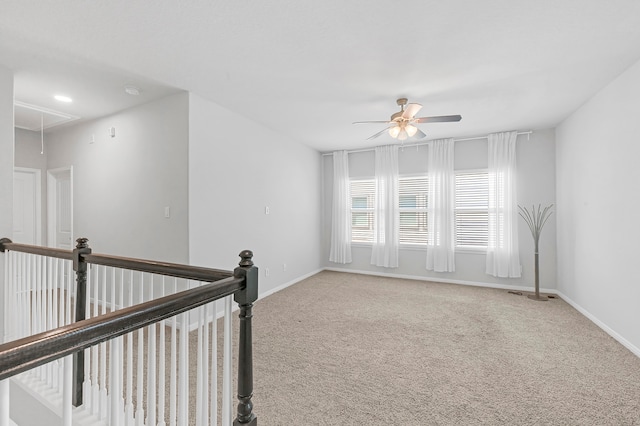 carpeted spare room featuring ceiling fan