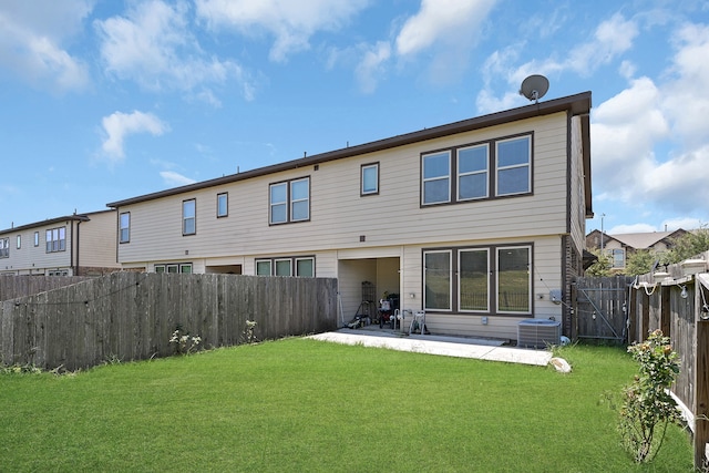 back of property with a yard, a patio area, and central AC