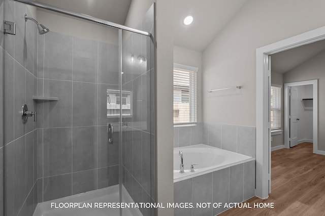 bathroom featuring vaulted ceiling, plus walk in shower, and hardwood / wood-style flooring