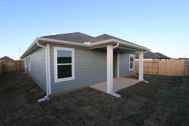 back of property with a patio area and a lawn