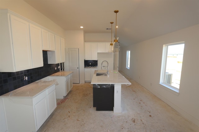 kitchen featuring white cabinetry, backsplash, a kitchen island with sink, hanging light fixtures, and sink