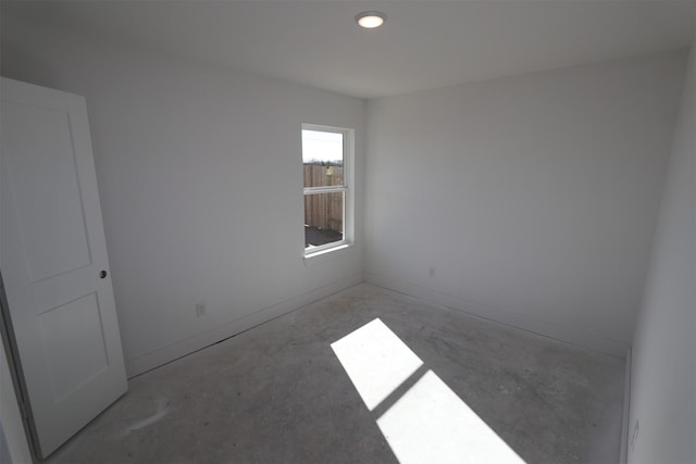 unfurnished room with concrete flooring