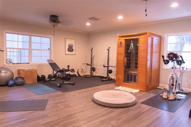 exercise room with ornamental molding, light hardwood / wood-style floors, and ceiling fan