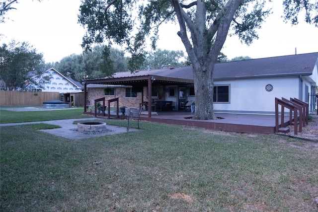 back of house with a wooden deck, a yard, a patio area, and an outdoor fire pit