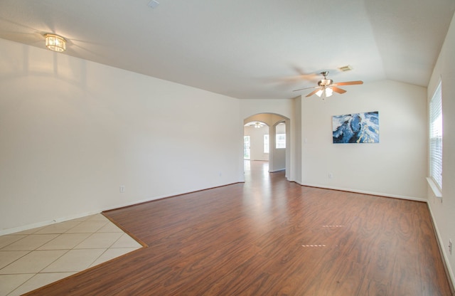 spare room with light wood-type flooring, vaulted ceiling, and ceiling fan