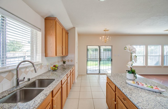 kitchen with backsplash, sink, pendant lighting, and plenty of natural light