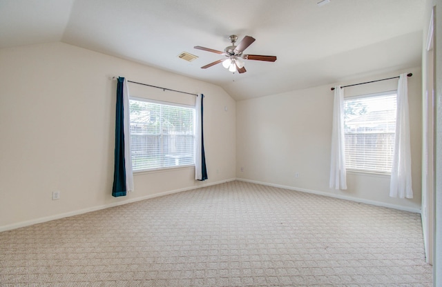 unfurnished room with a healthy amount of sunlight, vaulted ceiling, ceiling fan, and light carpet