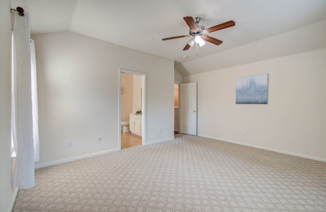 unfurnished bedroom with connected bathroom, vaulted ceiling, ceiling fan, and light carpet