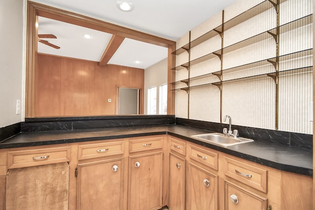 kitchen featuring beamed ceiling, sink, and ceiling fan