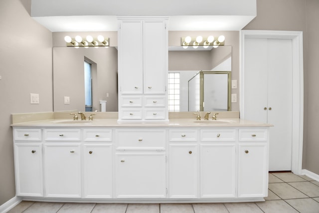 bathroom featuring tile patterned flooring, an enclosed shower, and vanity