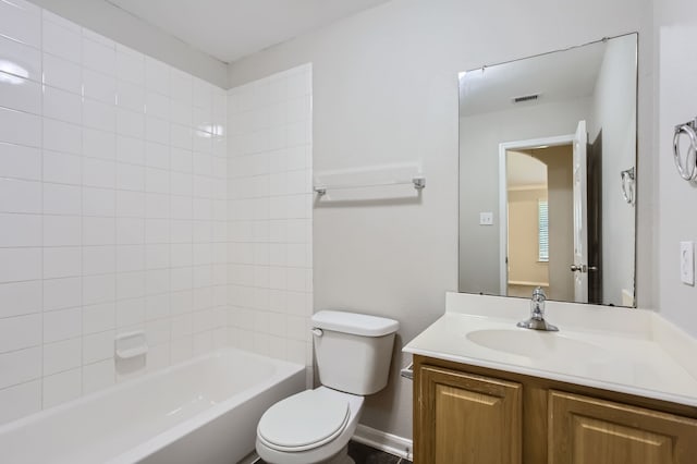 full bathroom with tiled shower / bath, vanity, and toilet