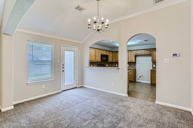 unfurnished living room with ornamental molding, dark colored carpet, and a chandelier